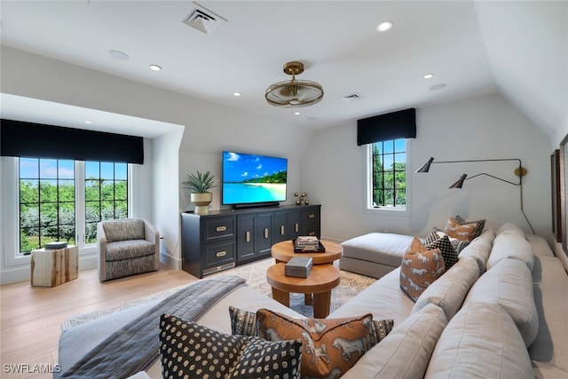 living room featuring light hardwood / wood-style floors and vaulted ceiling