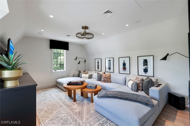 living room featuring light hardwood / wood-style floors and vaulted ceiling