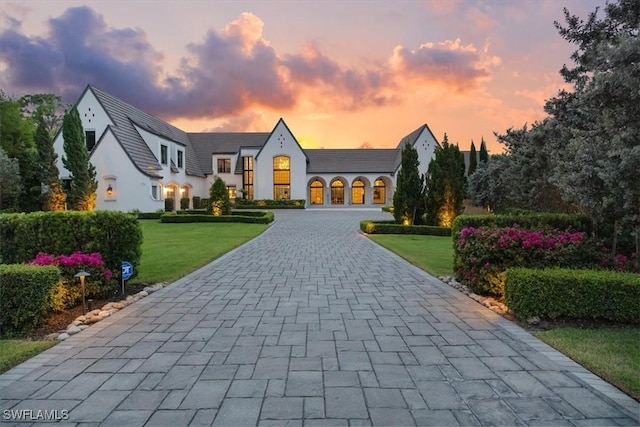254 Audubon Blvd, Naples, FL 34110 - view of front facade featuring curved driveway, a lawn, and stucco siding