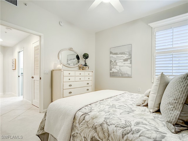 bedroom with light tile patterned flooring, ceiling fan, and a closet