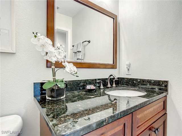 bathroom featuring vanity and toilet