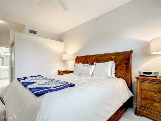 carpeted bedroom with ensuite bathroom and ceiling fan