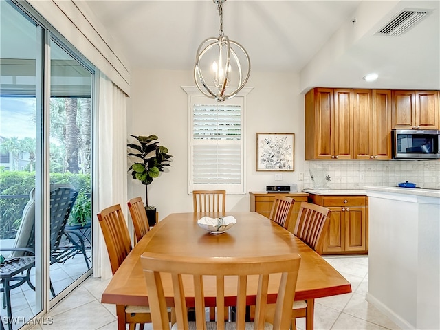 tiled dining room featuring a notable chandelier