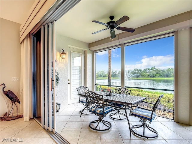 sunroom / solarium with a water view and ceiling fan