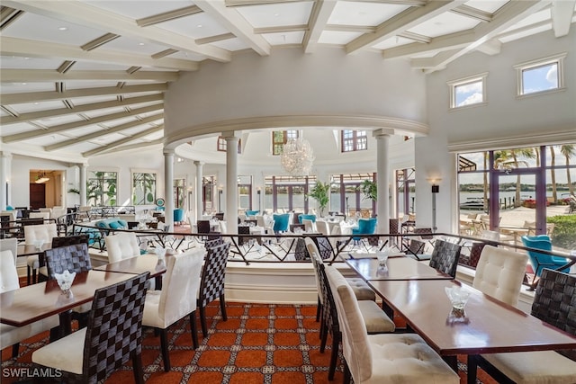 dining room with carpet flooring, a chandelier, beamed ceiling, decorative columns, and high vaulted ceiling