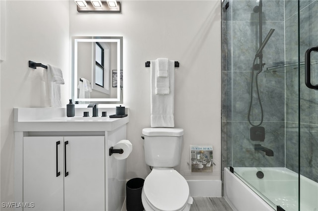 full bathroom featuring shower / bath combination with glass door, vanity, and toilet