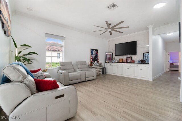 living room featuring ceiling fan, light wood-type flooring, and crown molding