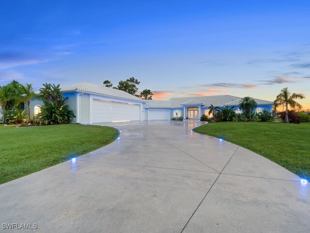 ranch-style home with a yard and a garage