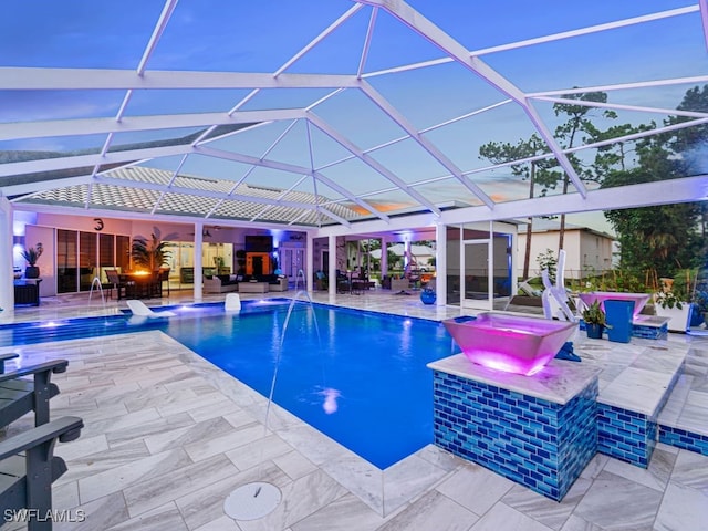 view of pool with glass enclosure, pool water feature, and a patio