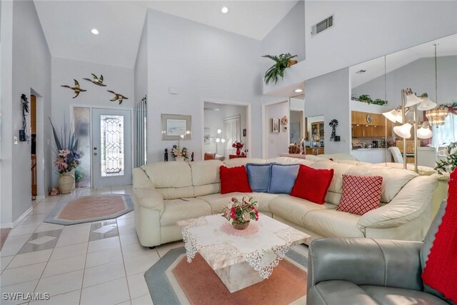 living room featuring a notable chandelier, light tile patterned floors, and high vaulted ceiling