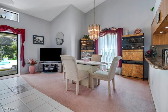 dining space featuring tile patterned flooring, an inviting chandelier, and high vaulted ceiling