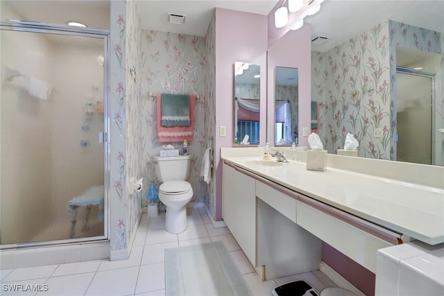 bathroom featuring a shower with door, vanity, toilet, and tile patterned floors