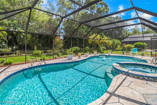 view of pool featuring a lanai and an in ground hot tub