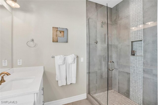 bathroom featuring tile patterned flooring, vanity, and a shower with shower door