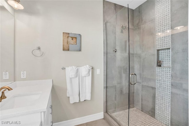 full bathroom with baseboards, a shower stall, vanity, and tile patterned floors