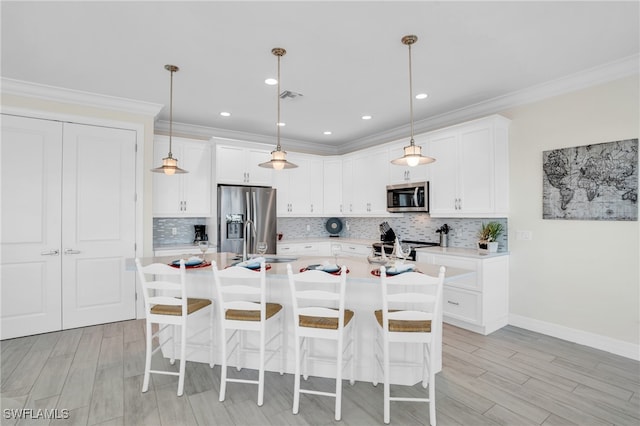 kitchen with white cabinets, sink, stainless steel appliances, and a kitchen island with sink