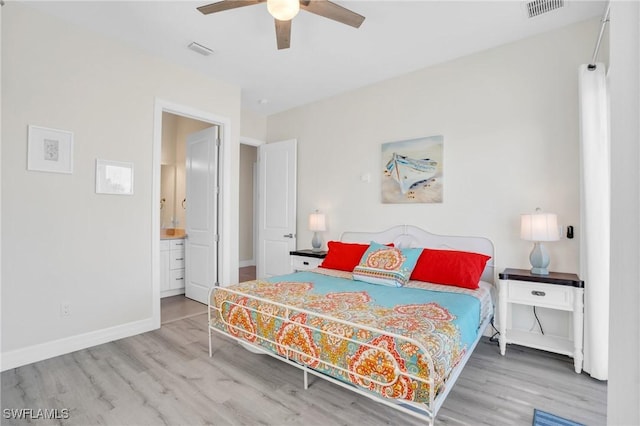 bedroom with baseboards, visible vents, and wood finished floors