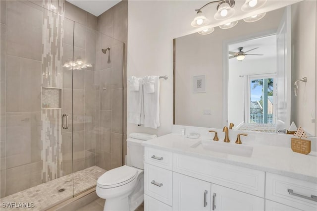 bathroom featuring toilet, a shower stall, vanity, and a ceiling fan