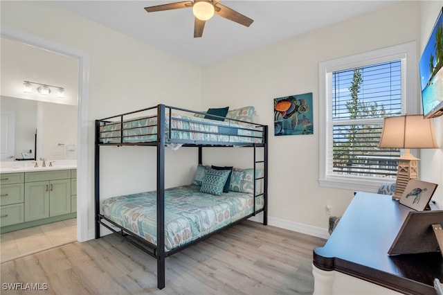 bedroom with ensuite bathroom, sink, ceiling fan, and light wood-type flooring