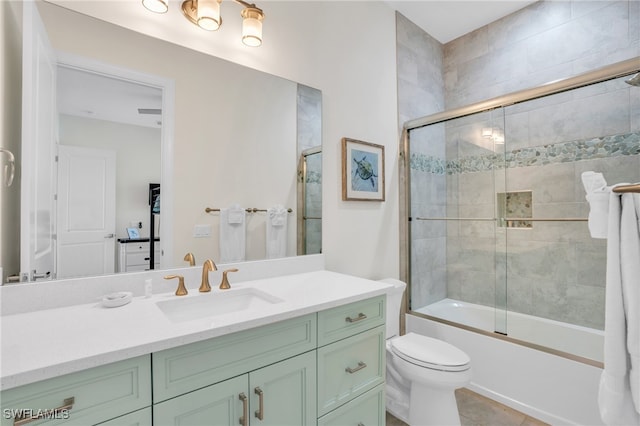 full bathroom with tile patterned floors, vanity, toilet, and bath / shower combo with glass door