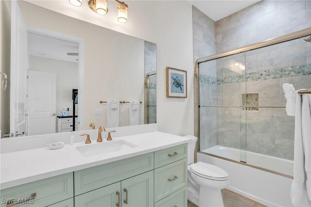 full bath featuring shower / bath combination with glass door, vanity, toilet, and tile patterned floors