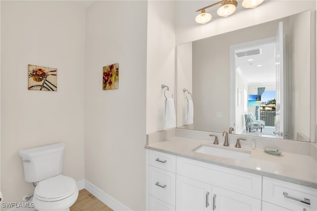 bathroom with vanity, hardwood / wood-style flooring, and toilet