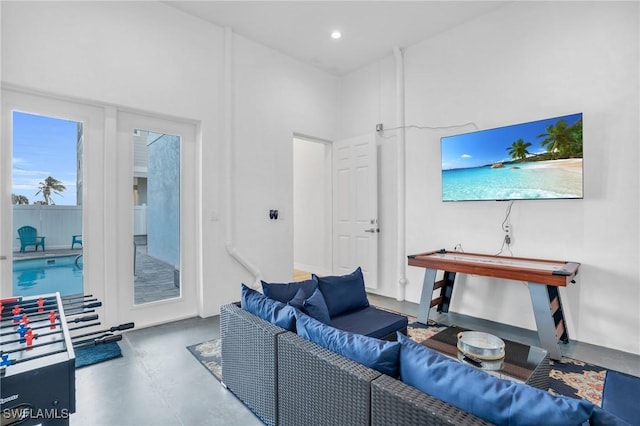 living room featuring recessed lighting, finished concrete flooring, and a towering ceiling