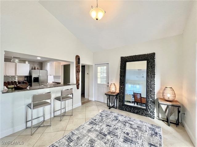 living room featuring high vaulted ceiling and light tile patterned flooring