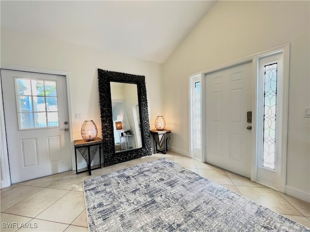 foyer entrance with vaulted ceiling and light tile patterned flooring