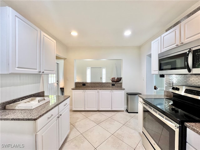 kitchen with white cabinets, stainless steel appliances, decorative backsplash, and light tile patterned flooring