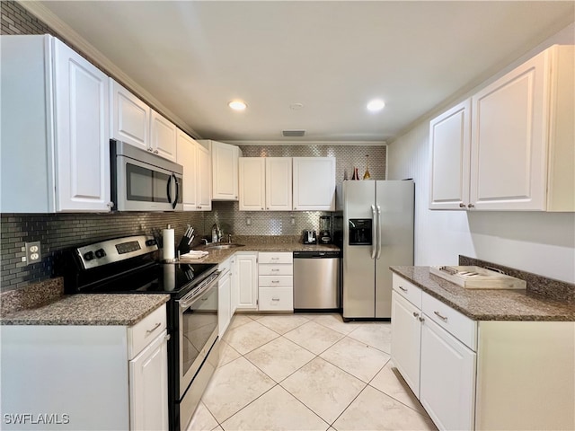 kitchen with light tile patterned floors, tasteful backsplash, stainless steel appliances, and white cabinets