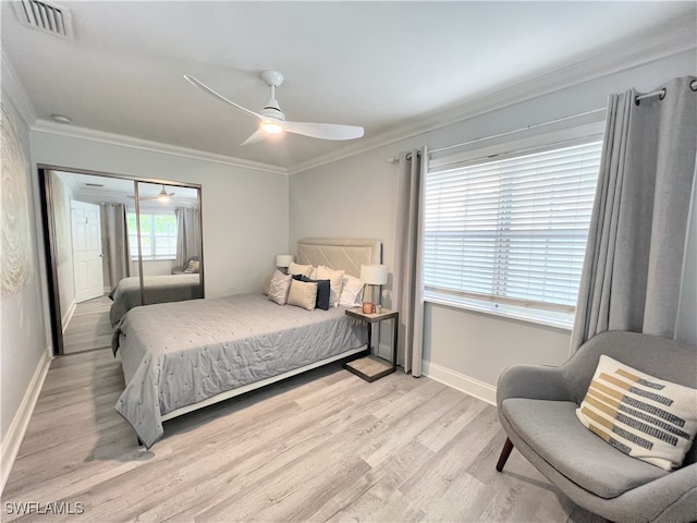 bedroom featuring crown molding, light hardwood / wood-style flooring, ceiling fan, and a closet