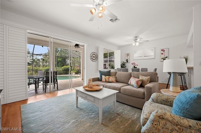 living room with ceiling fan, a sunroom, wood finished floors, and visible vents