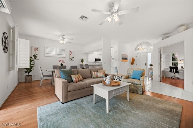 living room with ceiling fan and light hardwood / wood-style flooring