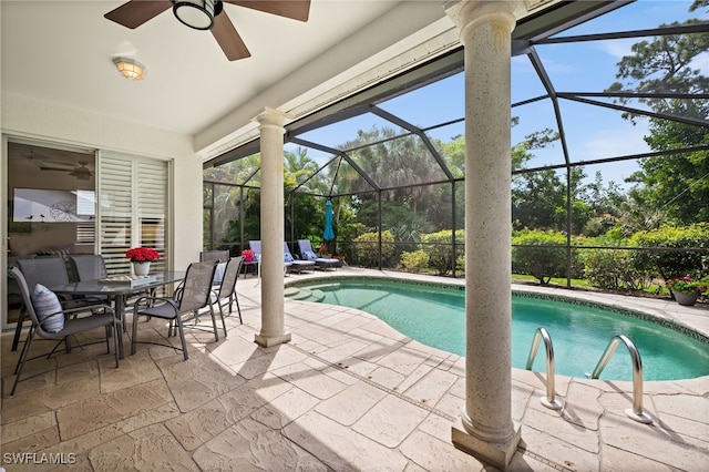 view of pool featuring a patio, glass enclosure, and ceiling fan