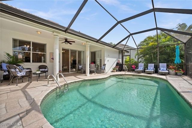 pool featuring ceiling fan, glass enclosure, and a patio area