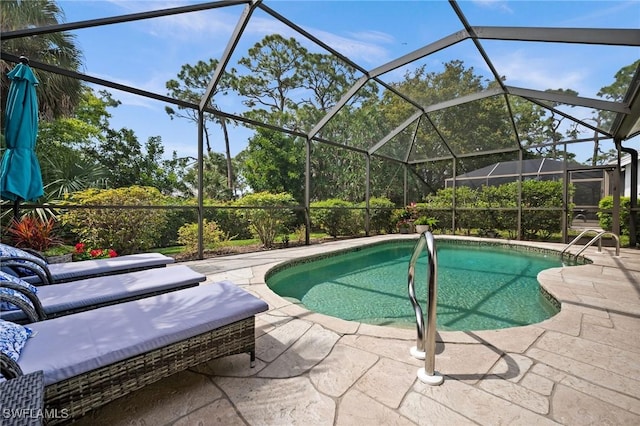 view of pool with a patio and glass enclosure