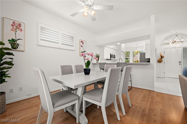 dining space with ceiling fan and light hardwood / wood-style floors