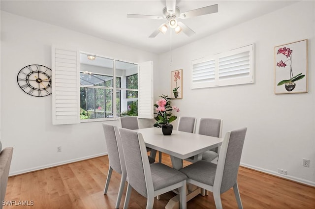 dining space with a ceiling fan, baseboards, and wood finished floors