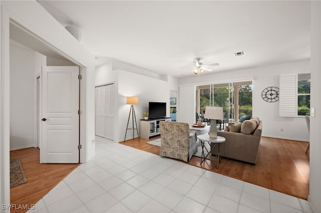 living room with light wood-type flooring and ceiling fan