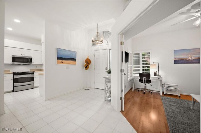 entryway featuring ceiling fan with notable chandelier