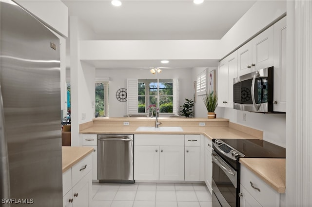 kitchen with white cabinetry, sink, ceiling fan, stainless steel appliances, and light tile patterned floors