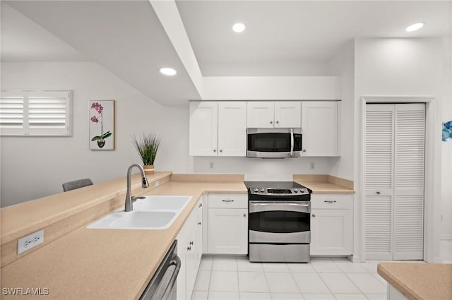 kitchen with recessed lighting, a sink, white cabinetry, light countertops, and appliances with stainless steel finishes