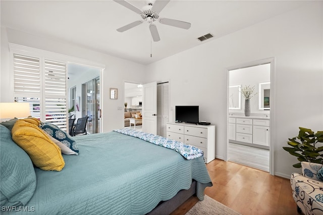 bedroom with ceiling fan, a closet, light wood-type flooring, and ensuite bath