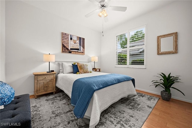 bedroom with ceiling fan, baseboards, and wood finished floors