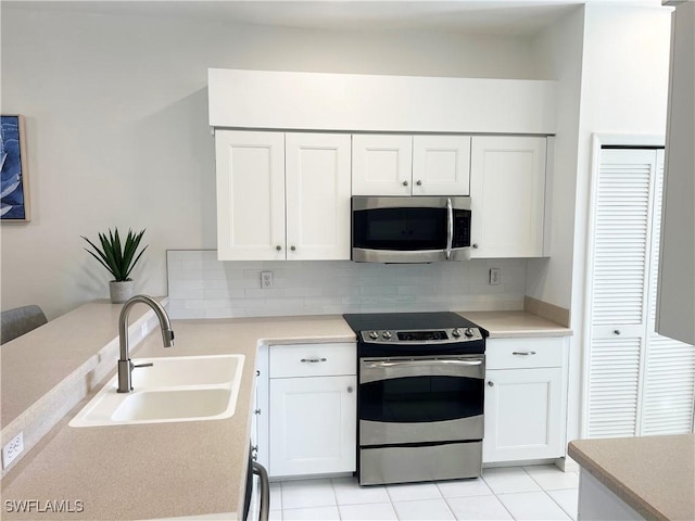 25040 Bay Cedar Dr, Bonita Springs, FL 34134 - kitchen featuring a sink, light countertops, white cabinetry, stainless steel appliances, and backsplash
