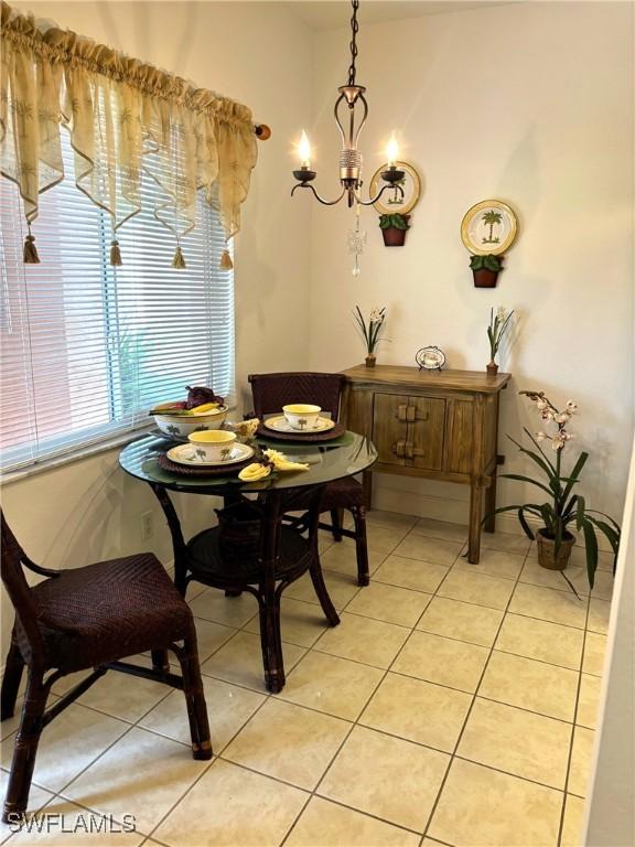 tiled dining room with an inviting chandelier