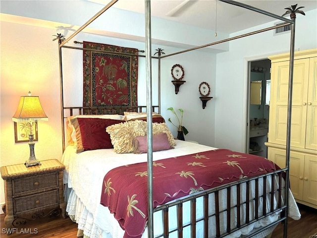 bedroom featuring ensuite bathroom and dark hardwood / wood-style flooring