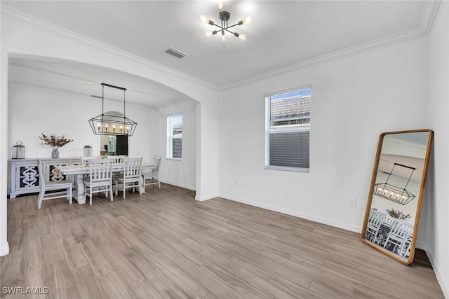 dining area featuring an inviting chandelier, crown molding, and light hardwood / wood-style flooring