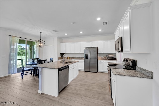 kitchen with light wood-type flooring, appliances with stainless steel finishes, an island with sink, and hanging light fixtures